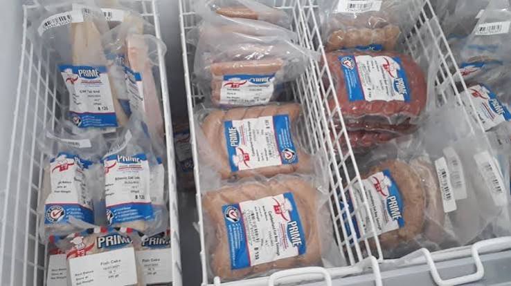 Packs of frozen sausages and fish cakes in a chest freezer