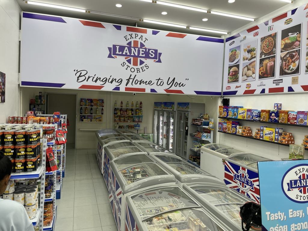 Inside Lane's Expat Stores, with the Bringing Home to You sign and freezer cabinets